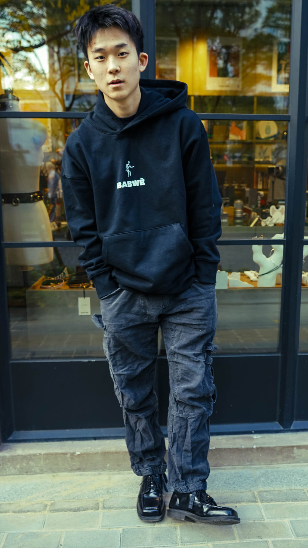 Detailed back shot of Babwê's black hoodie, showcasing the fusion of African art and contemporary fashion from Zimbabwe