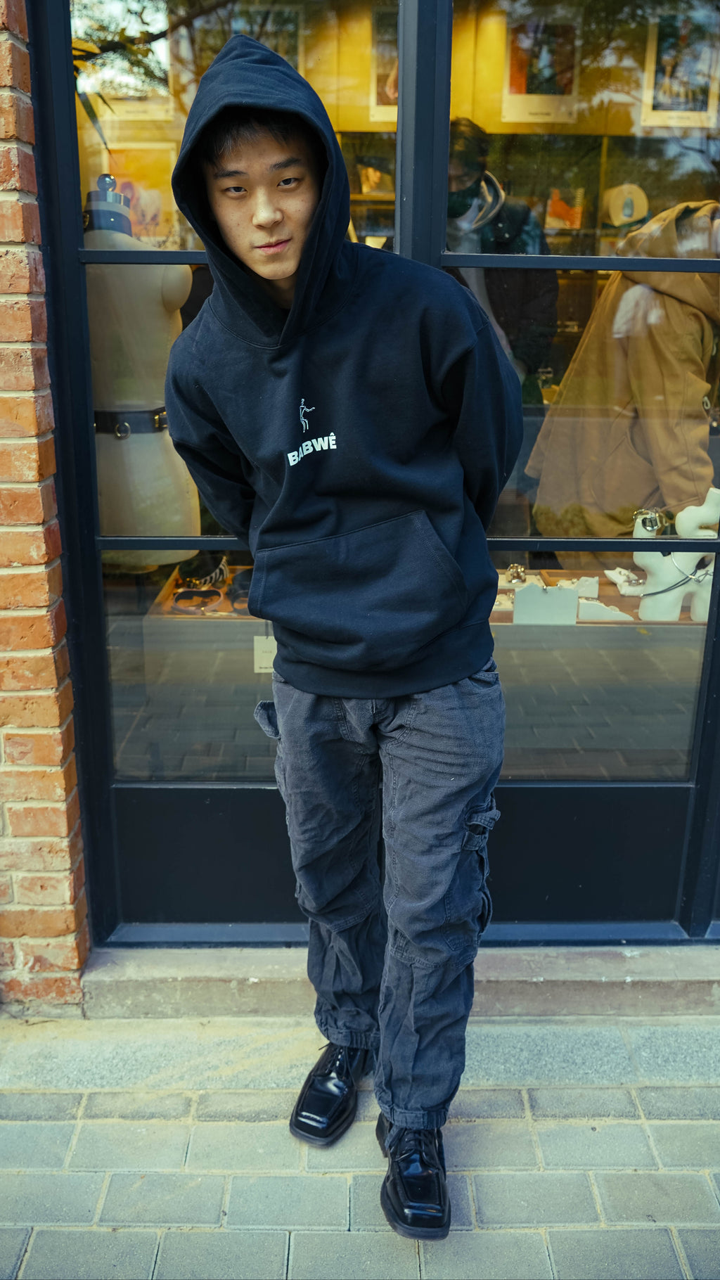 Front and back shots of Babwê's black hoodie, combining Zimbabwean heritage with global streetwear trends